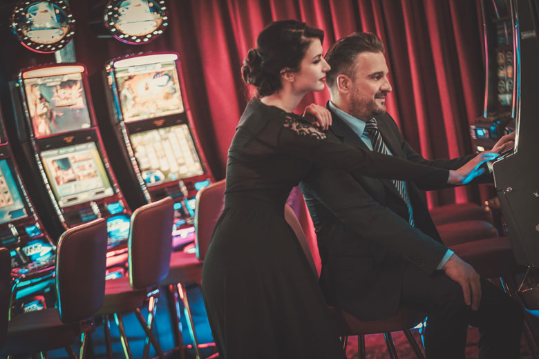 new slot machine releases - couple playing slot machine - real action slots